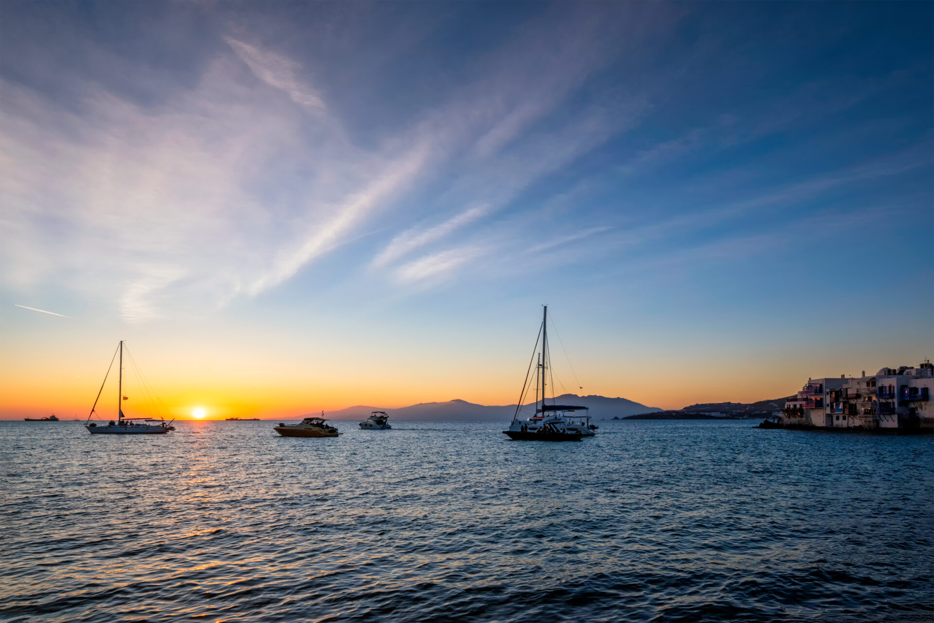 Sunset in Mykonos, Greece, with cruise ship and yachts in the harbor Sunset, Sea, and Silence: The Magic of Mykonos Sailing